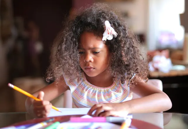Girl concentrating while writing with a pencil